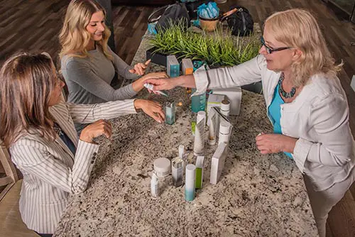 Debbi-jo offering samples of Neora products for two other women to try.